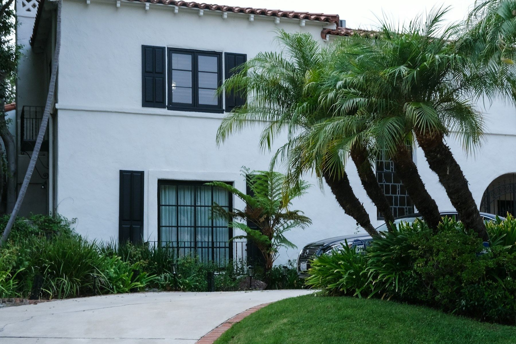 White stucco California home with mature landscaping
